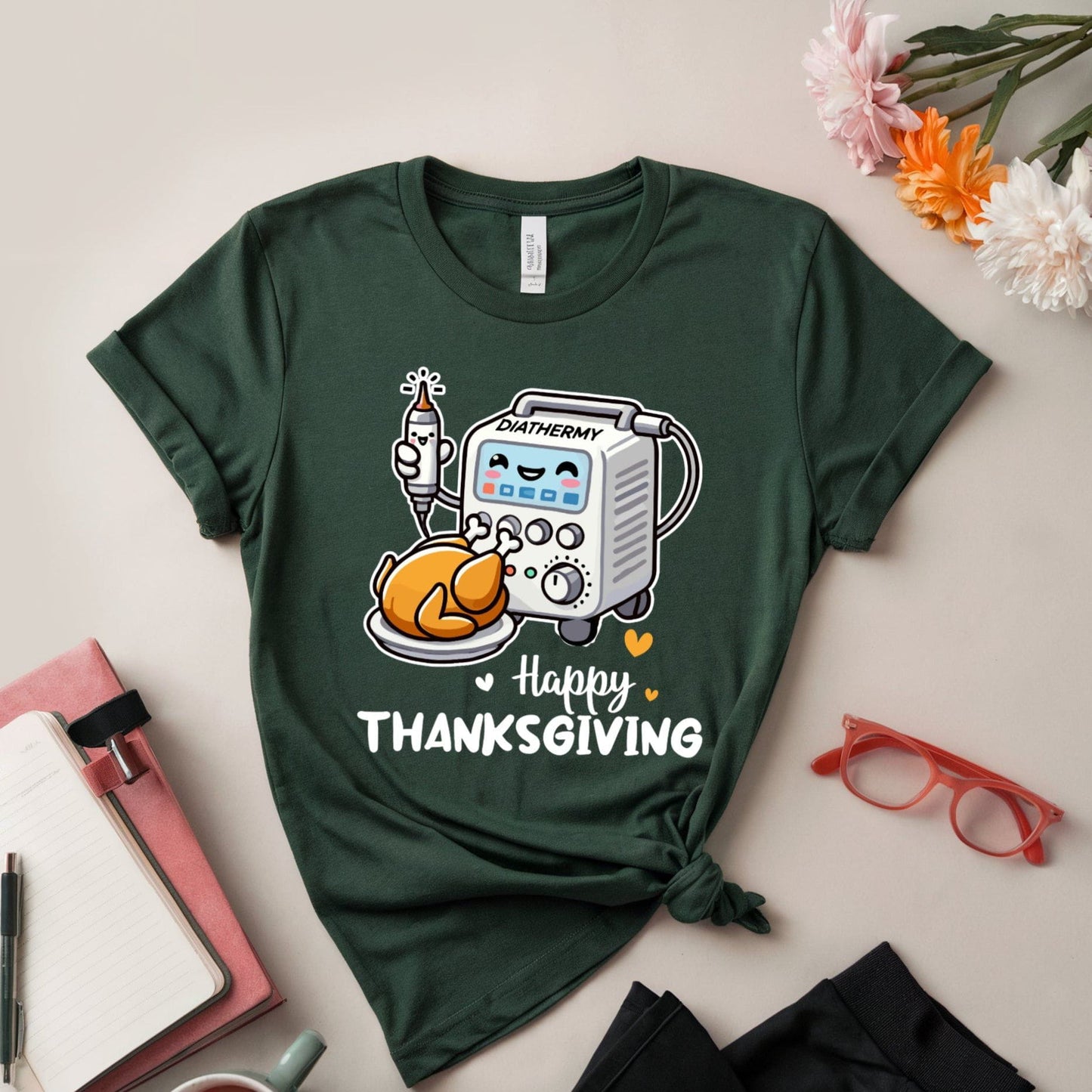 Green t-shirt with Thanksgiving design for OR/Theatre crew on a light surface with accessories.