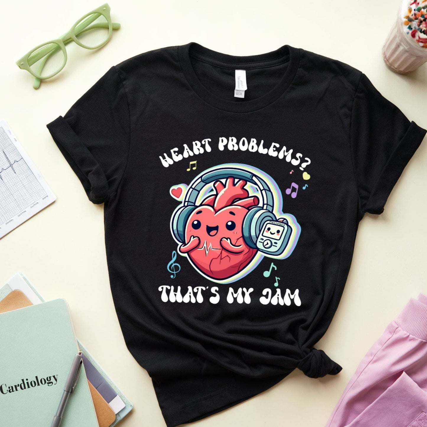 Black t-shirt with a heart-themed graphic and text on a light surface with accessories.