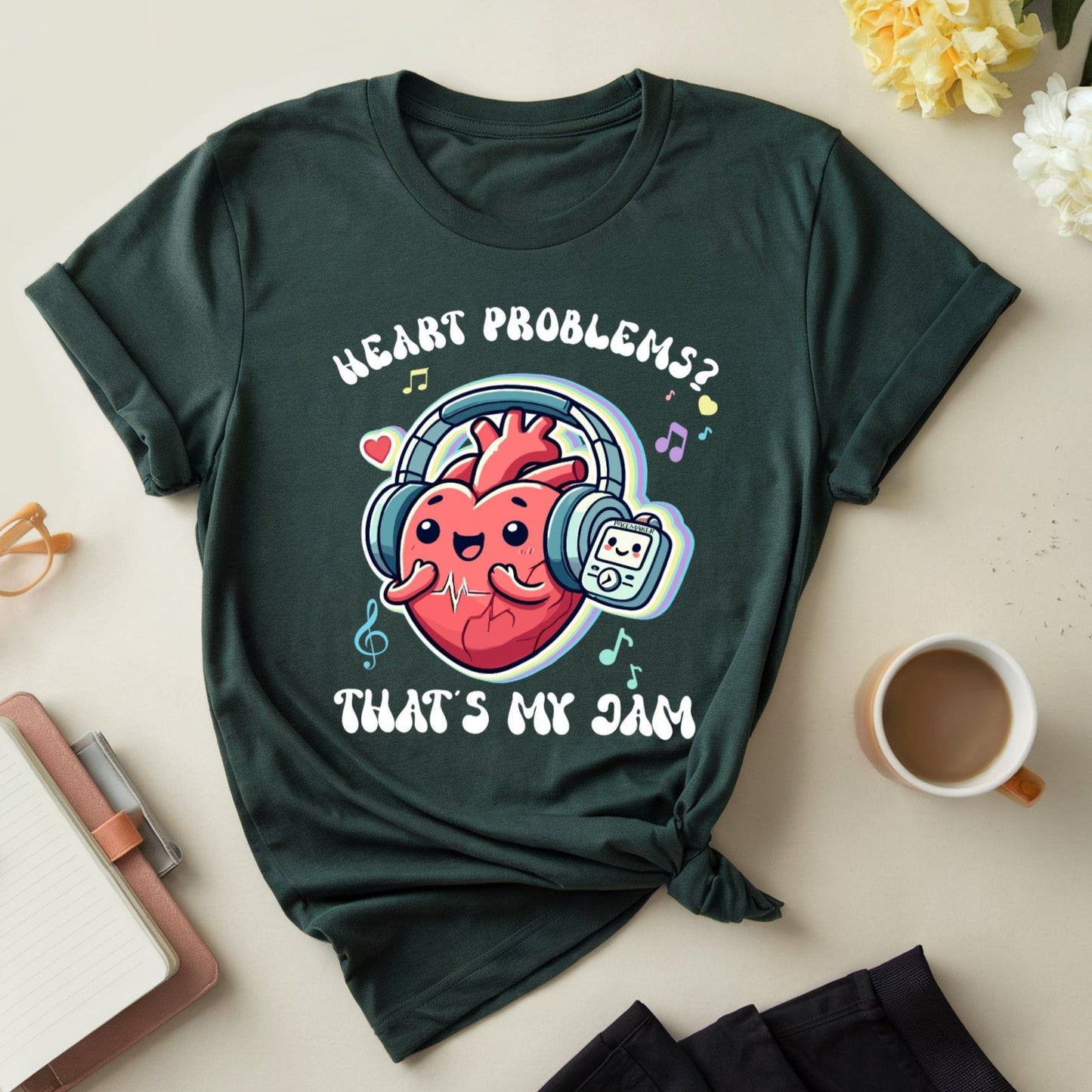 Green t-shirt with a heart graphic and text on a light surface with accessories.