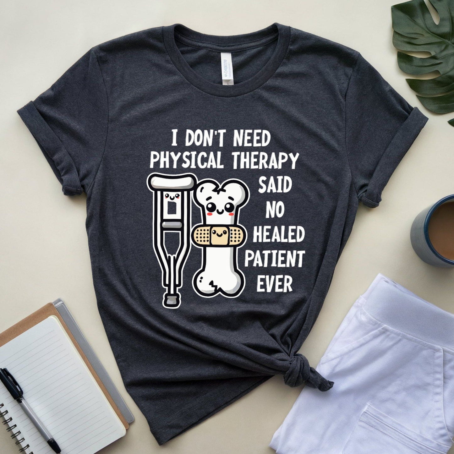 Dark heather grey t-shirt for orthopedics with humorous graphic and text on a light surface with accessories.