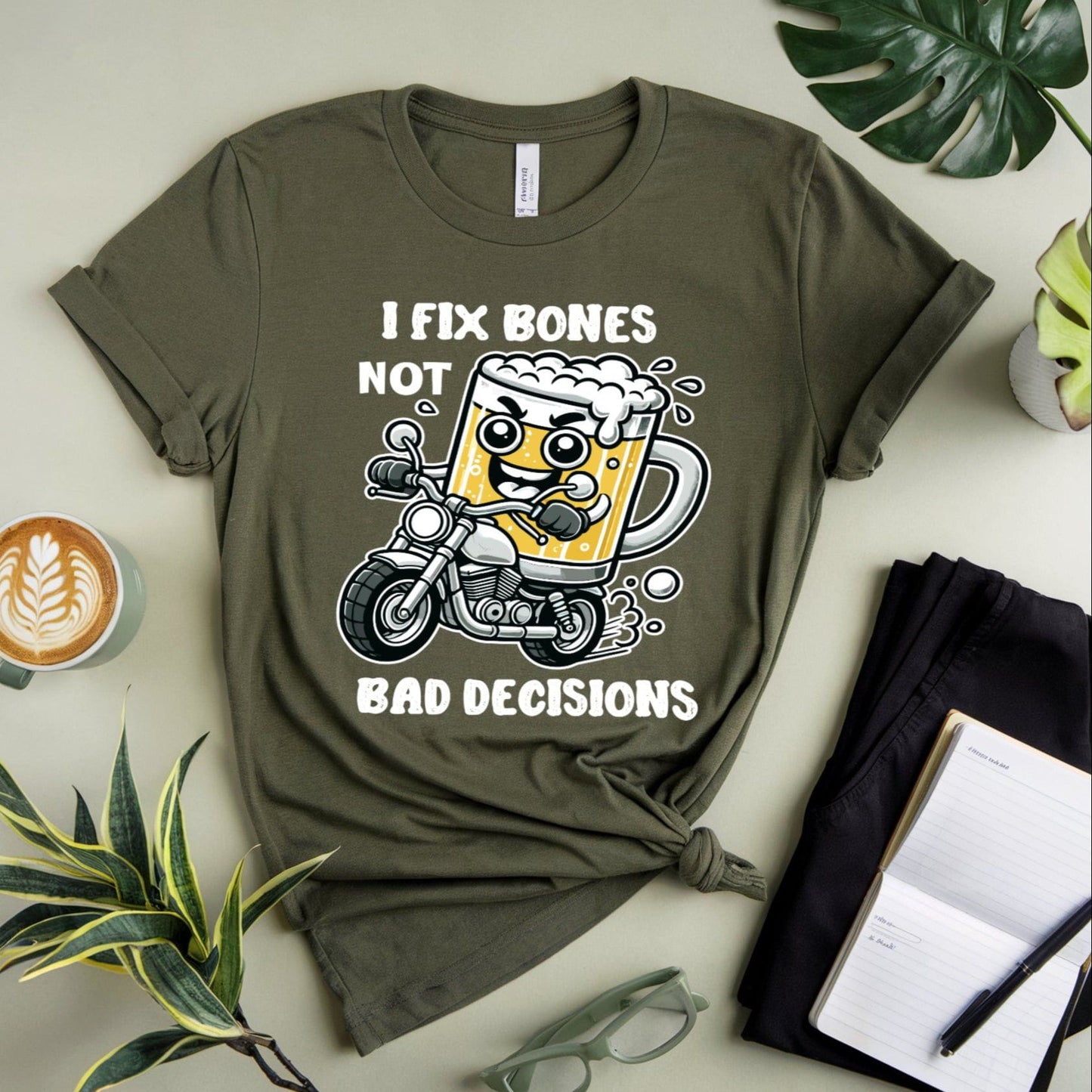 Green t-shirt for orthopedics with a graphic design on a light surface with plants and a coffee cup.