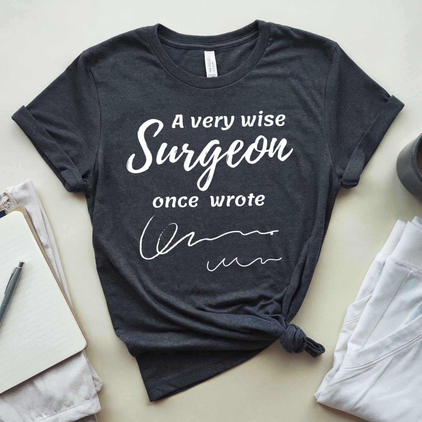 Black t-shirt  for surgeons with humorous text on a light surface with accessories