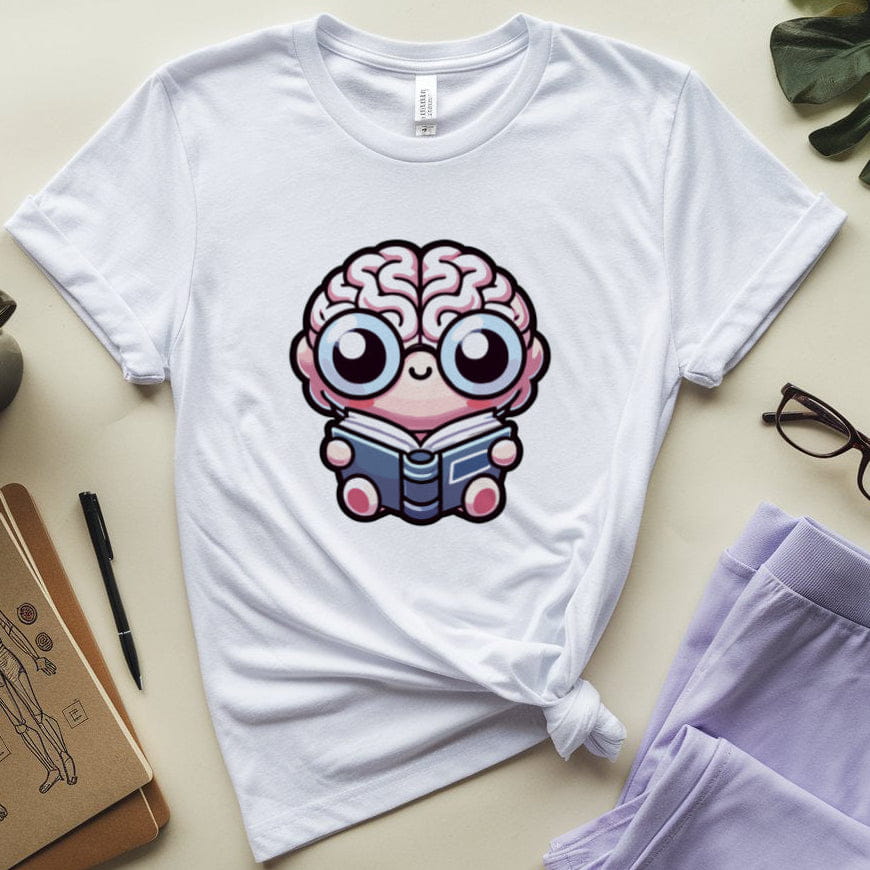 White t-shirt with a brain character reading a book graphic, placed on a surface with a coffee cup, glasses, and notebook.