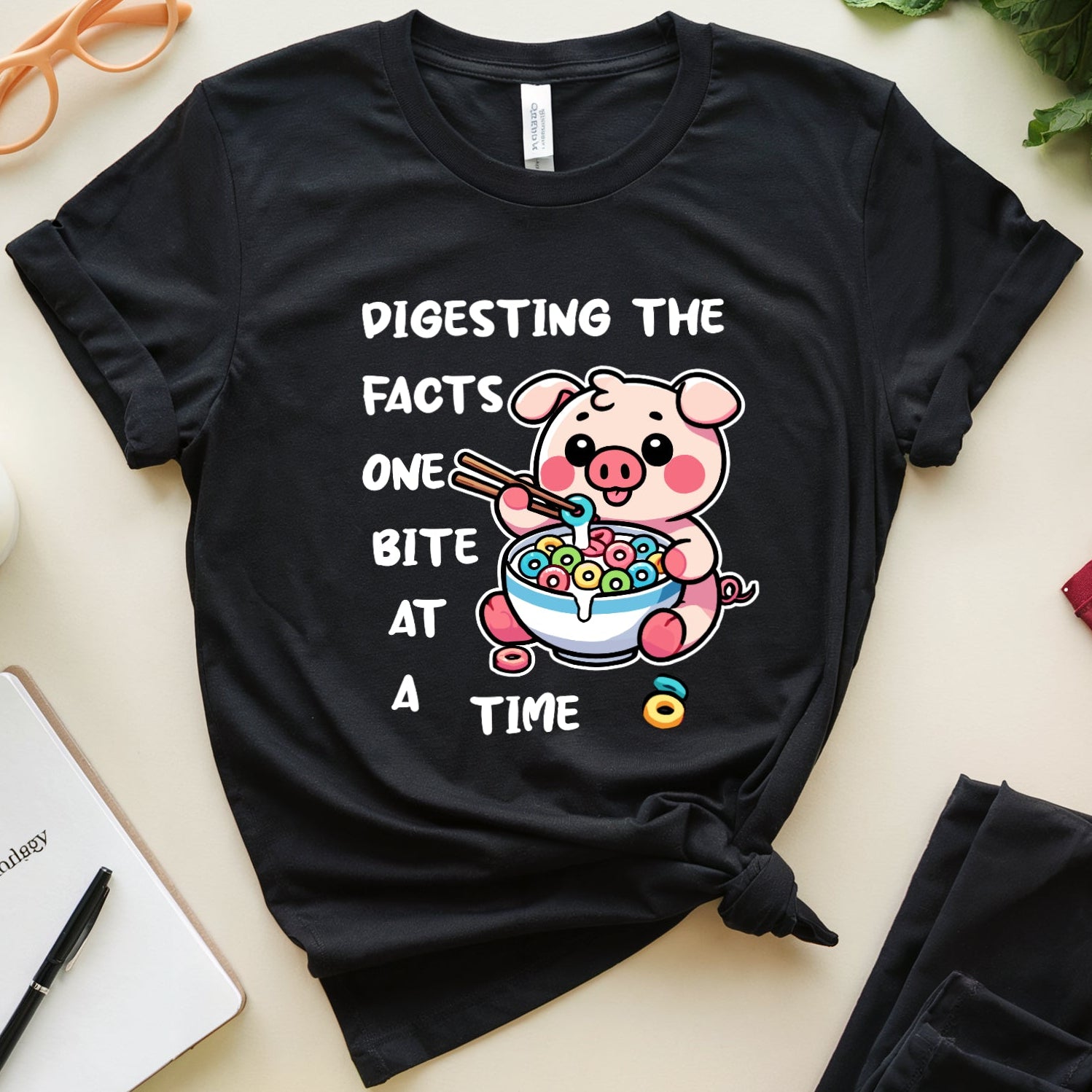 Black t-shirt with a cartoon pig eating cereal.