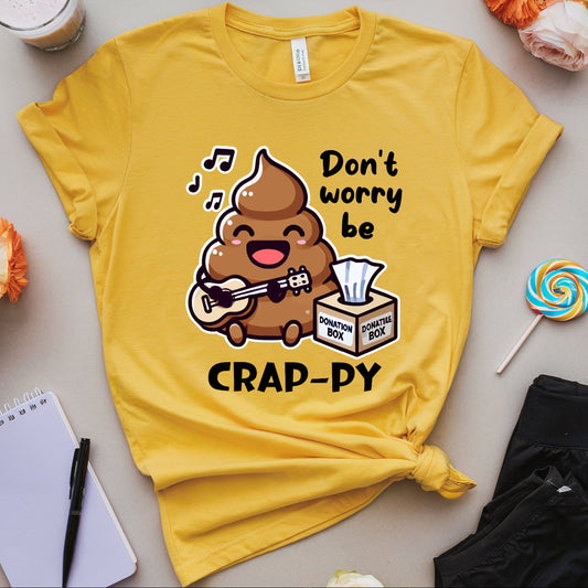 Yellow t-shirt with a cartoon poop singing don't worry be crappy with tissue donation box.