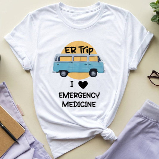 White t-shirt with 'ER Trip I ❤️ Emergency Medicine' graphic on a light surface with accessories.