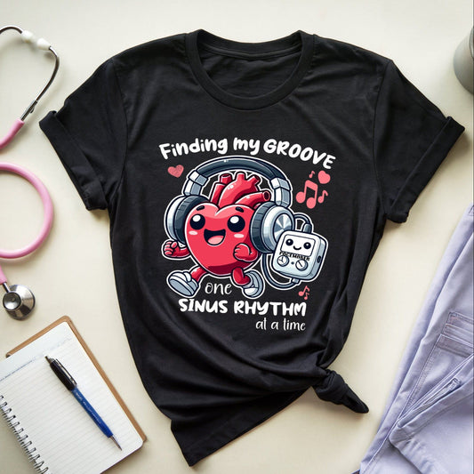 Black t-shirt with a heart graphic and text  for cardiologists on a light surface with medical equipment.