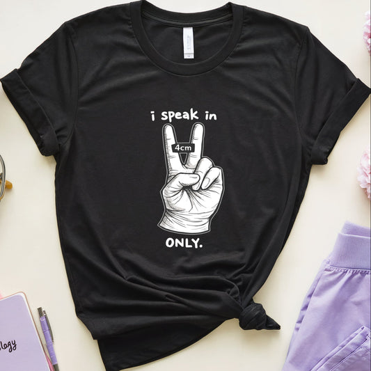 Black t-shirt with a peace sign graphic and text on a light surface with flowers and glasses.