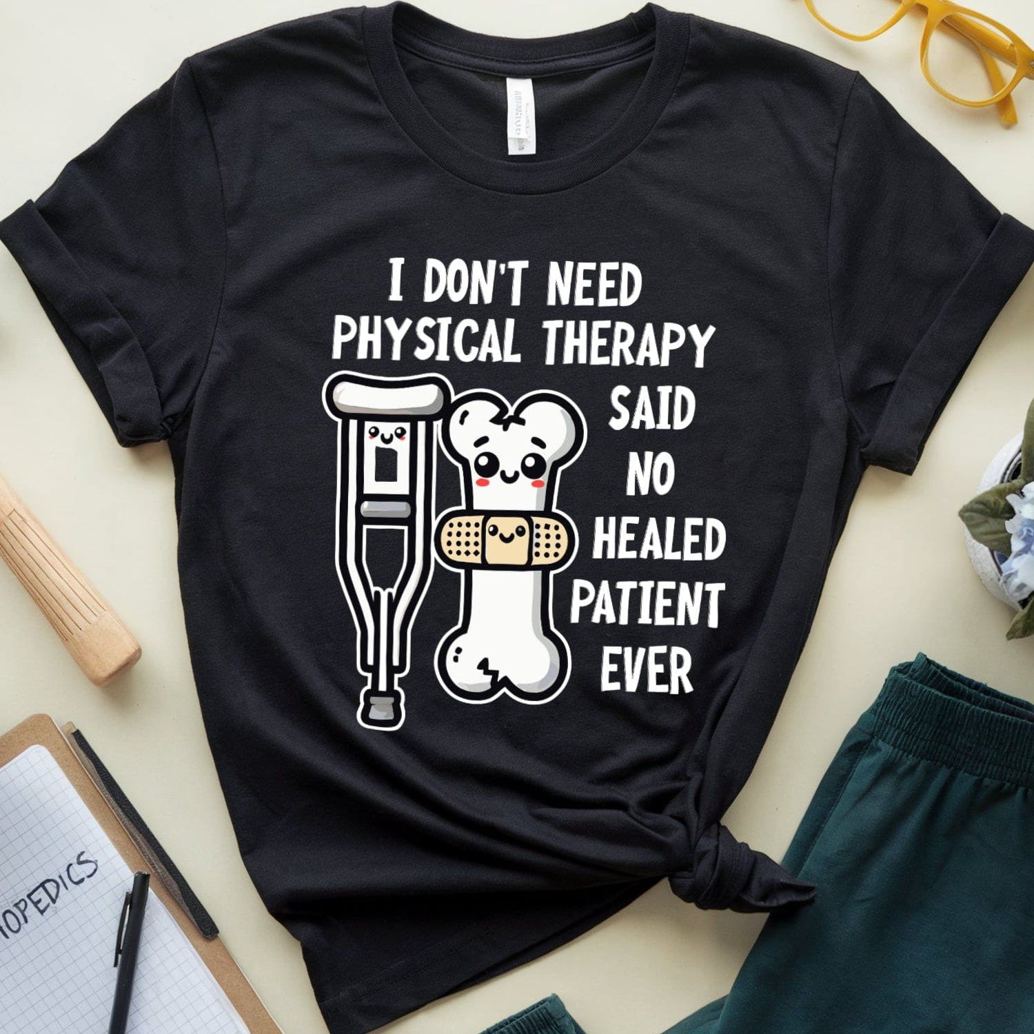 Black t-shirt  for orthopedics with humorous text and graphics on a light surface with accessories.