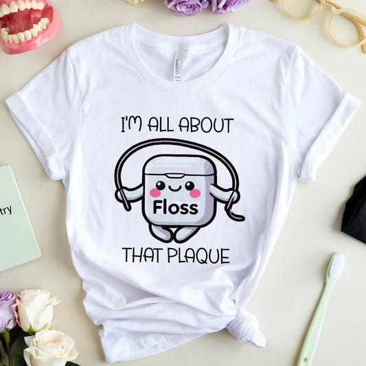 White t-shirt with dental-themed graphic and text on a table with dental items.