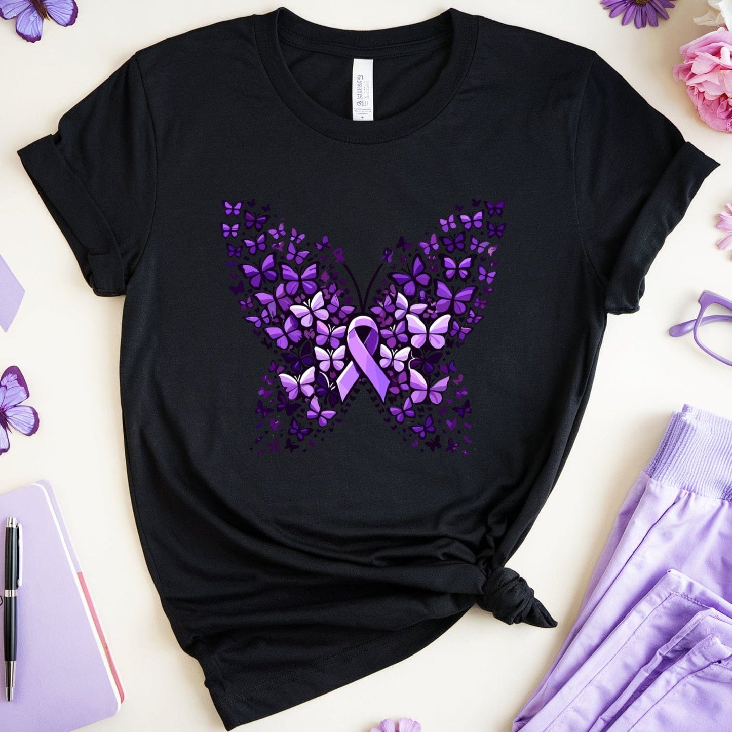 Black t-shirt with purple butterfly design featuring a ribbon, surrounded by purple and pink flowers, a notebook, pen, and glasses.