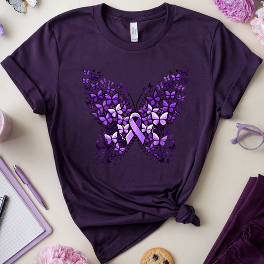 Purple t-shirt with butterfly design on a light surface with flowers and glasses.