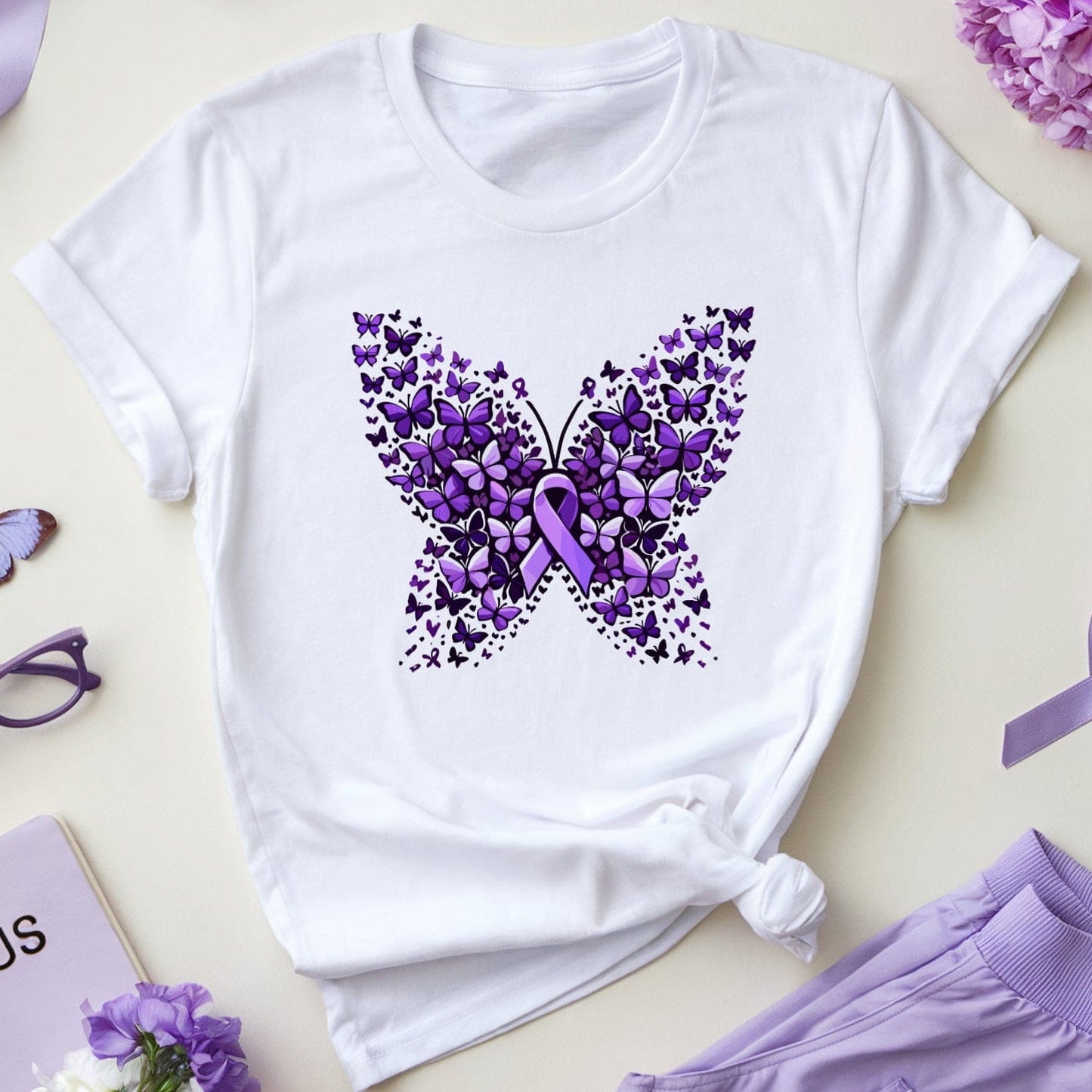 White t-shirt with purple butterfly design, lupus notebook, and purple ribbons on a light background