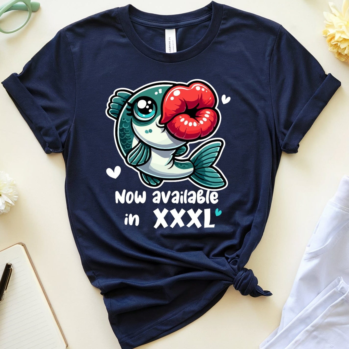 Navy blue t-shirt with a fish graphic and text on a light surface with accessories.