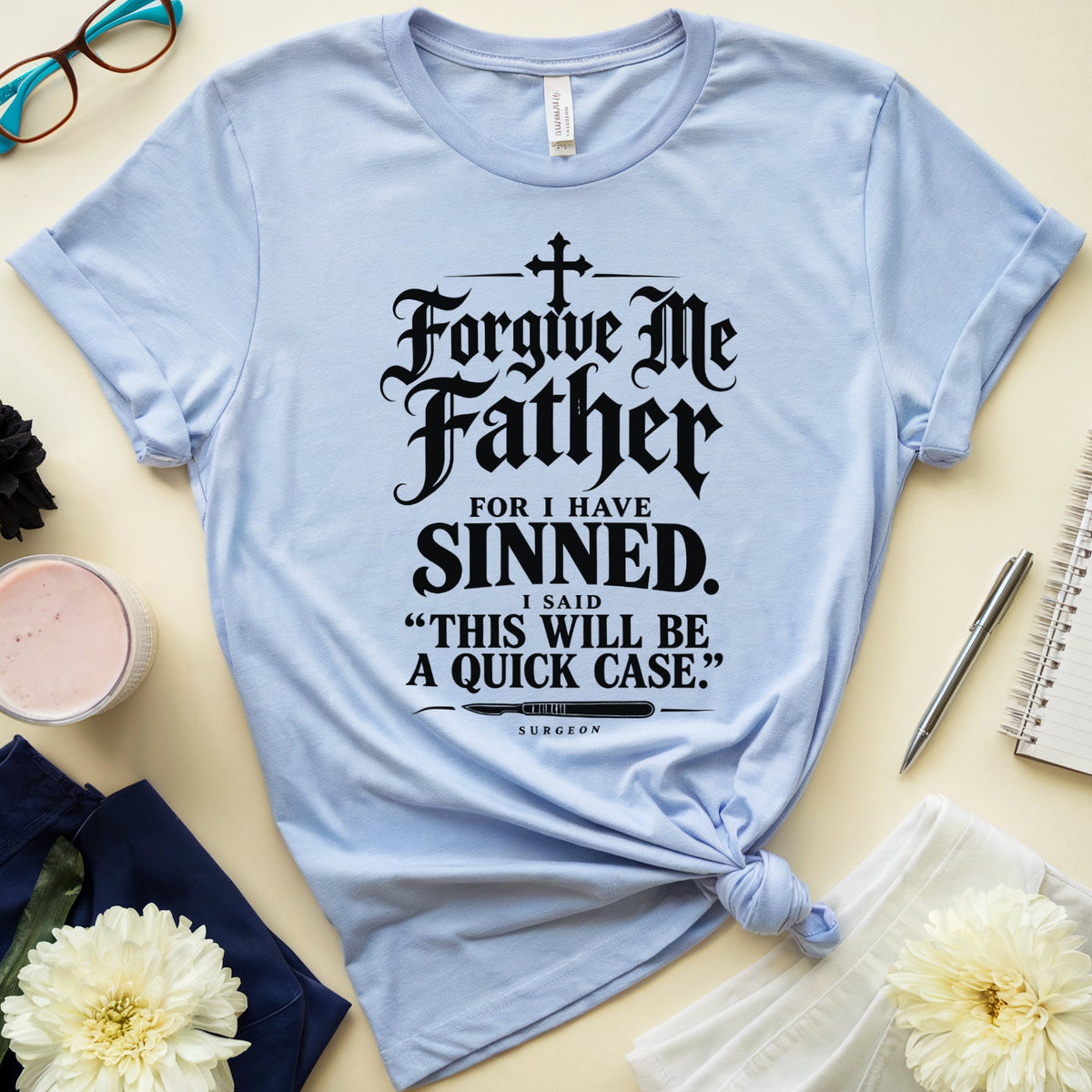 A light blue graphic t-shirt with a black gothic-style text print reading 'Forgive Me Father FOR I HAVE SINNED. I SAID "THIS WILL BE A QUICK CASE.