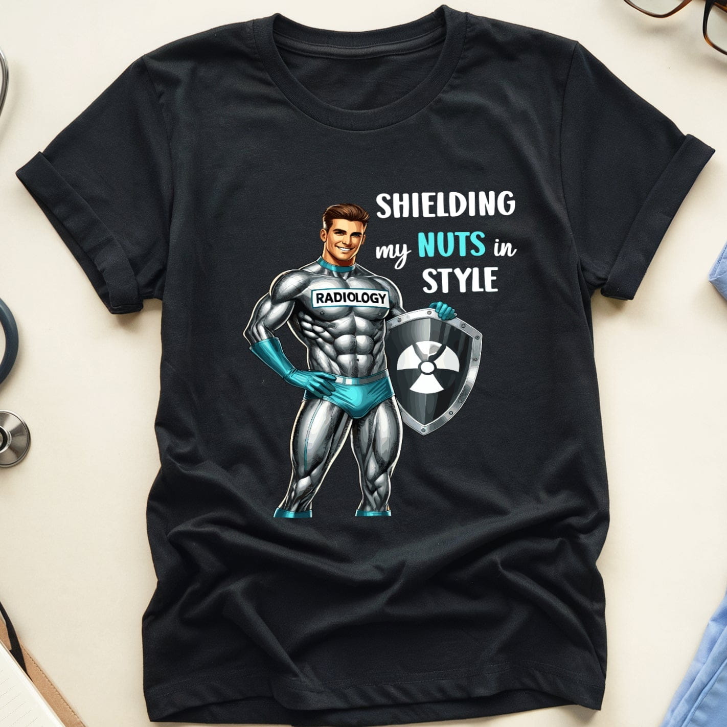 Black t-shirt with graphic design and text on a light surface with medical-themed items.