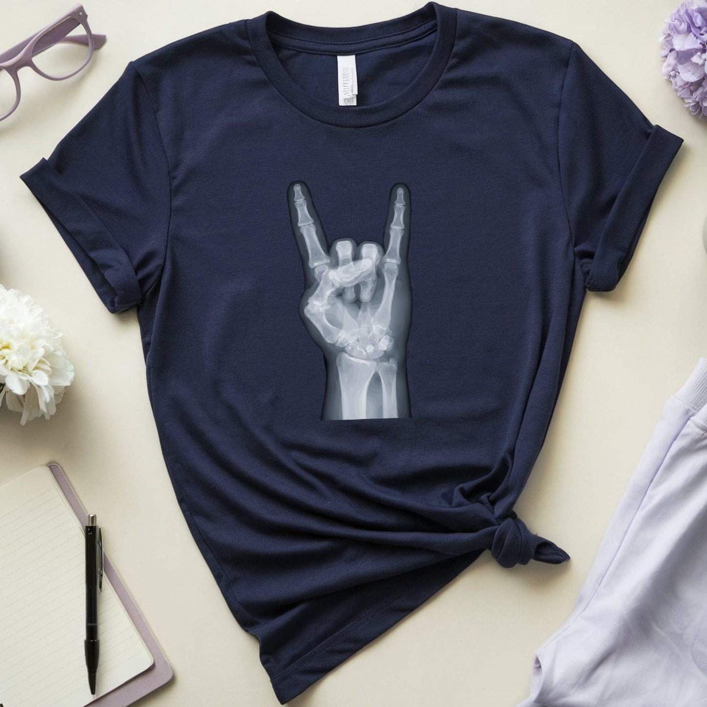 Navy blue t-shirt with a hand gesture design on a light surface with accessories.