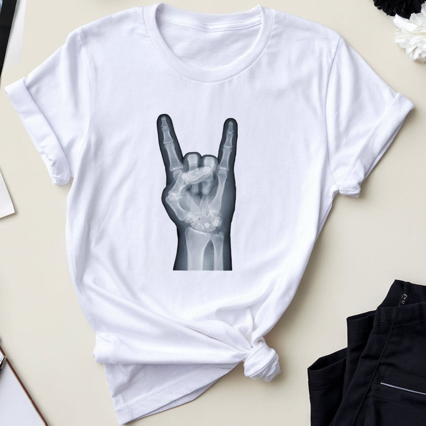 White t-shirt with black graphic design on a table with medical and casual items.