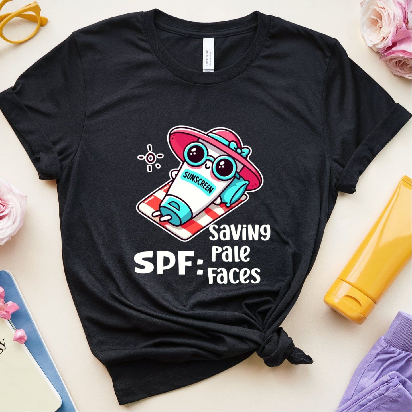 Black t-shirt with a cartoon character and 'Saving Pale Faces' text on a light surface with accessories.