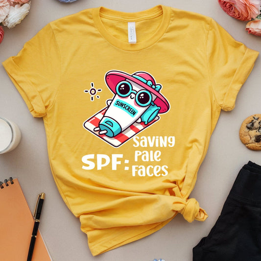 Yellow t-shirt with a cartoon owl design and text, surrounded by flowers, a notebook, and cookies on a light surface.