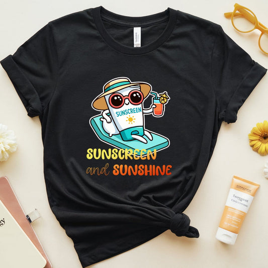 Black t-shirt with 'Sunscreen and Sunshine' design on a light surface with sunscreen and glasses.