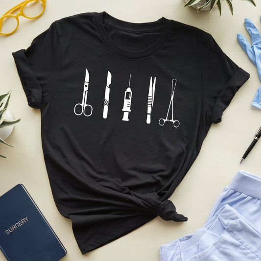 Black t-shirt with medical instrument design on a beige surface with accessories.