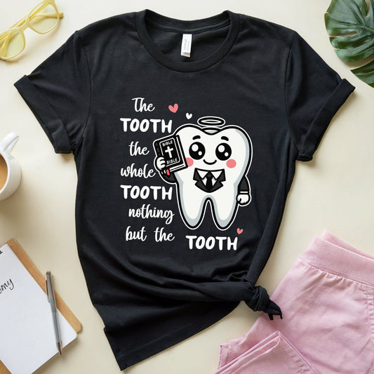 Black t-shirt with a tooth graphic and text on a light surface with accessories.